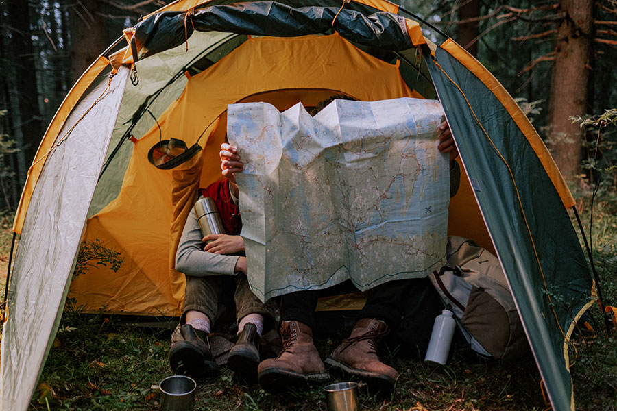 Osoby siedza w namiocie w lesie